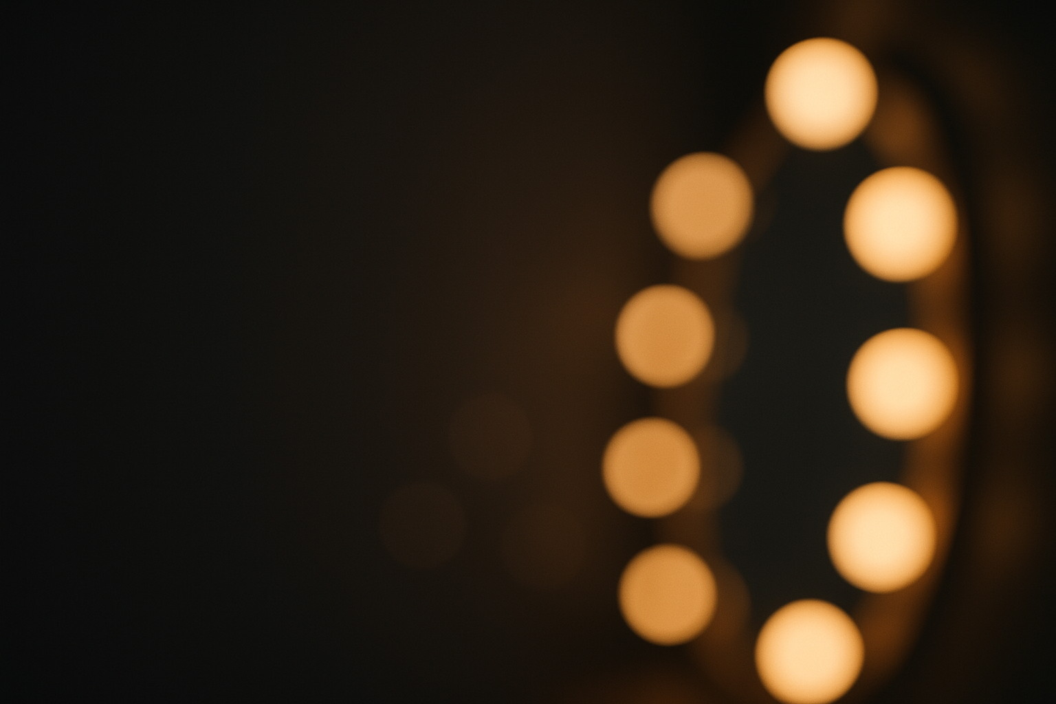 Warm golden vanity mirror lights on dark background